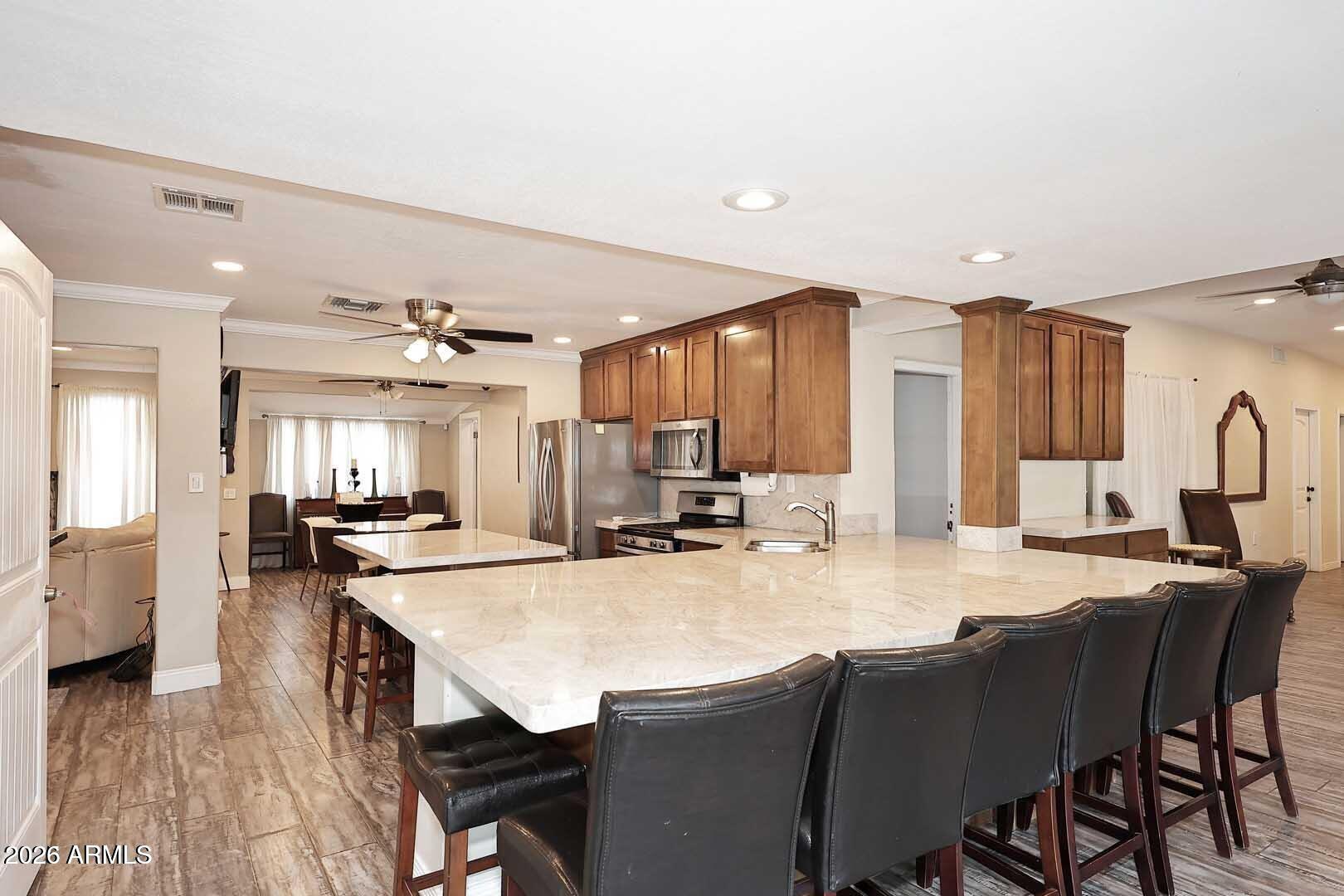 3502 North 22nd Street Phoenix, AZ 85016 - Photo 9 of 35 a kitchen with stainless steel appliances kitchen island granite countertop a dining table chairs and granite counter tops