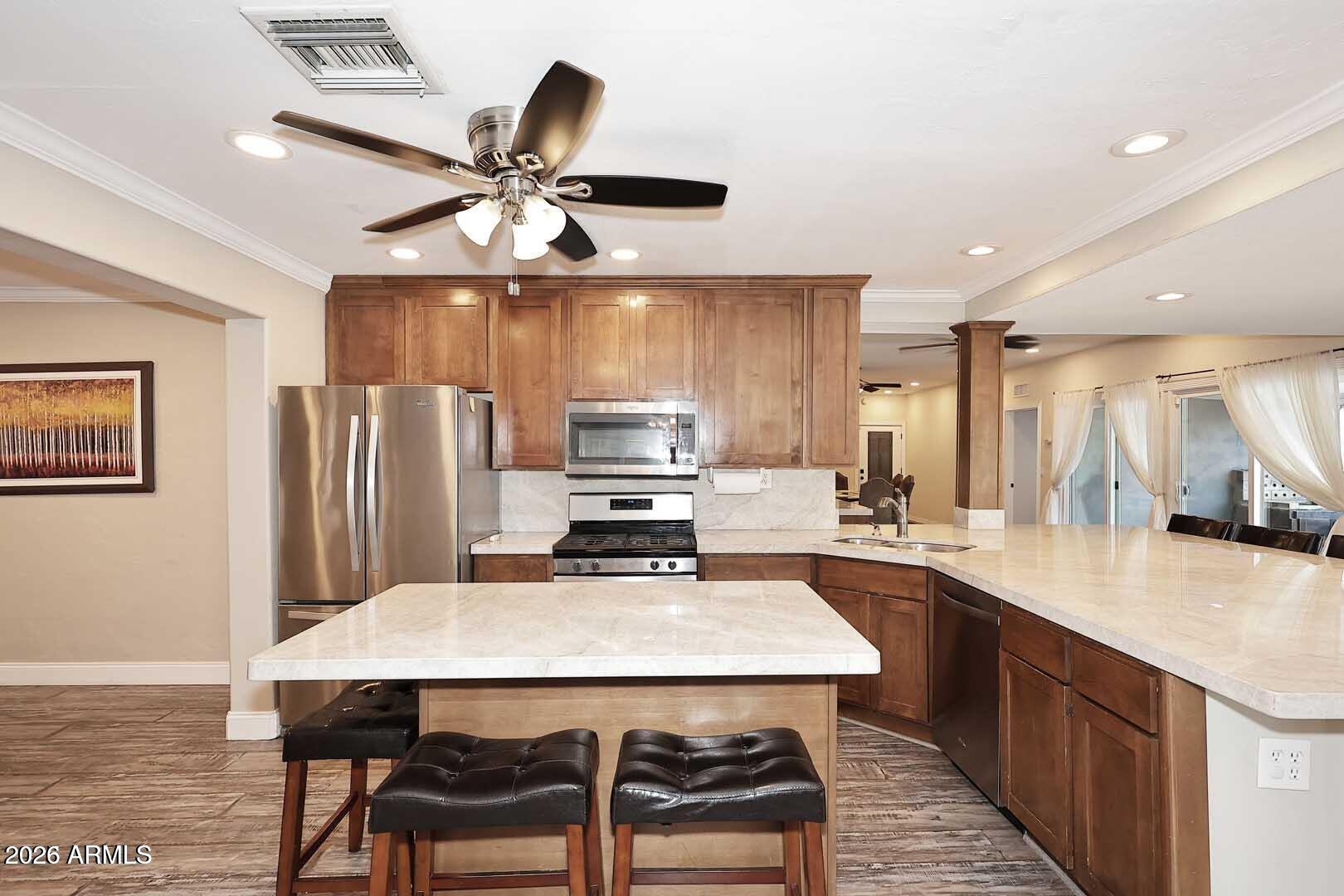 3502 North 22nd Street Phoenix, AZ 85016 - Photo 10 of 35 a kitchen with stainless steel appliances a table chairs and chandelier