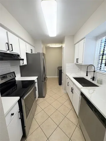 a kitchen with stainless steel appliances a sink stove and cabinets