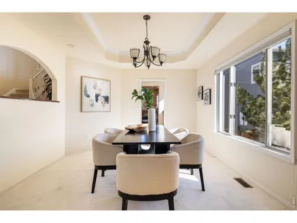 a dining room with furniture a chandelier and window