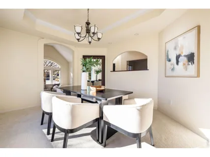 a view of a dining room with furniture and a chandelier