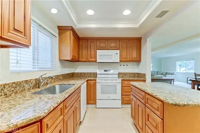 a kitchen with granite countertop a sink stove and cabinets