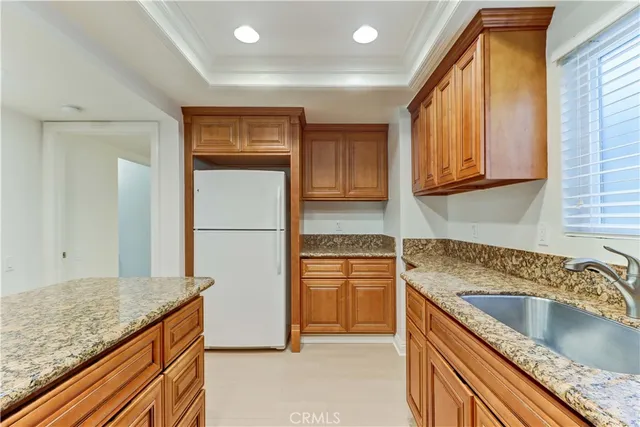 a kitchen with a refrigerator sink and cabinets