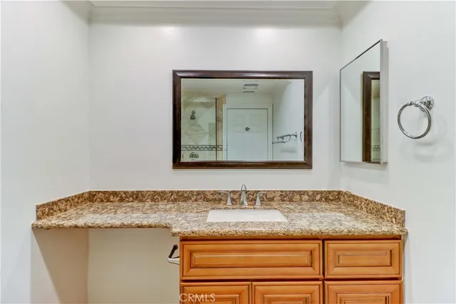 a bathroom with a granite countertop sink and a mirror