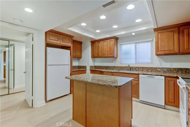 a kitchen with stainless steel appliances granite countertop a sink and a refrigerator