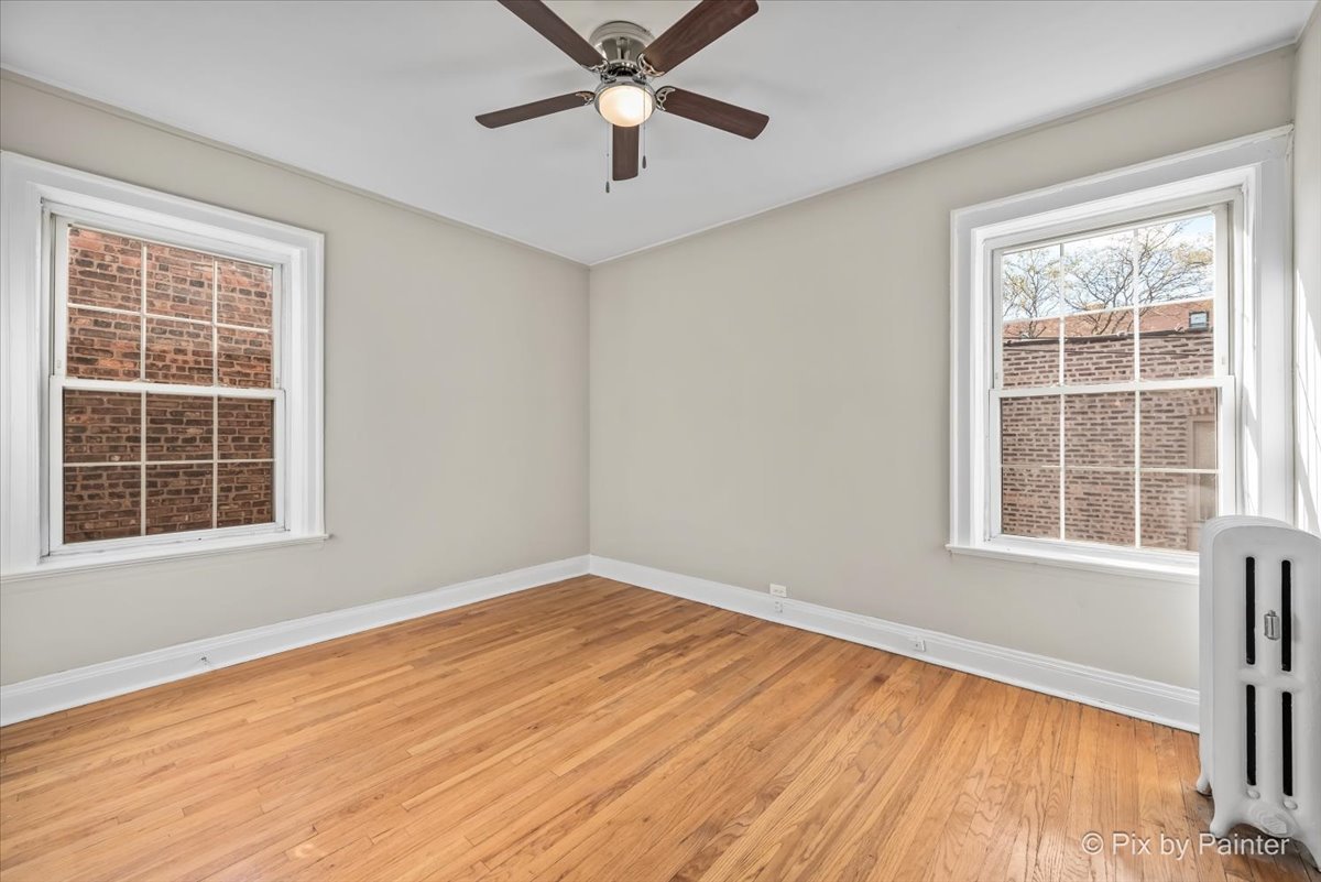 835 East 49th Street, Unit 3 Chicago, IL 60615 - Photo 13 of 16 an empty room with wooden floor fan and windows