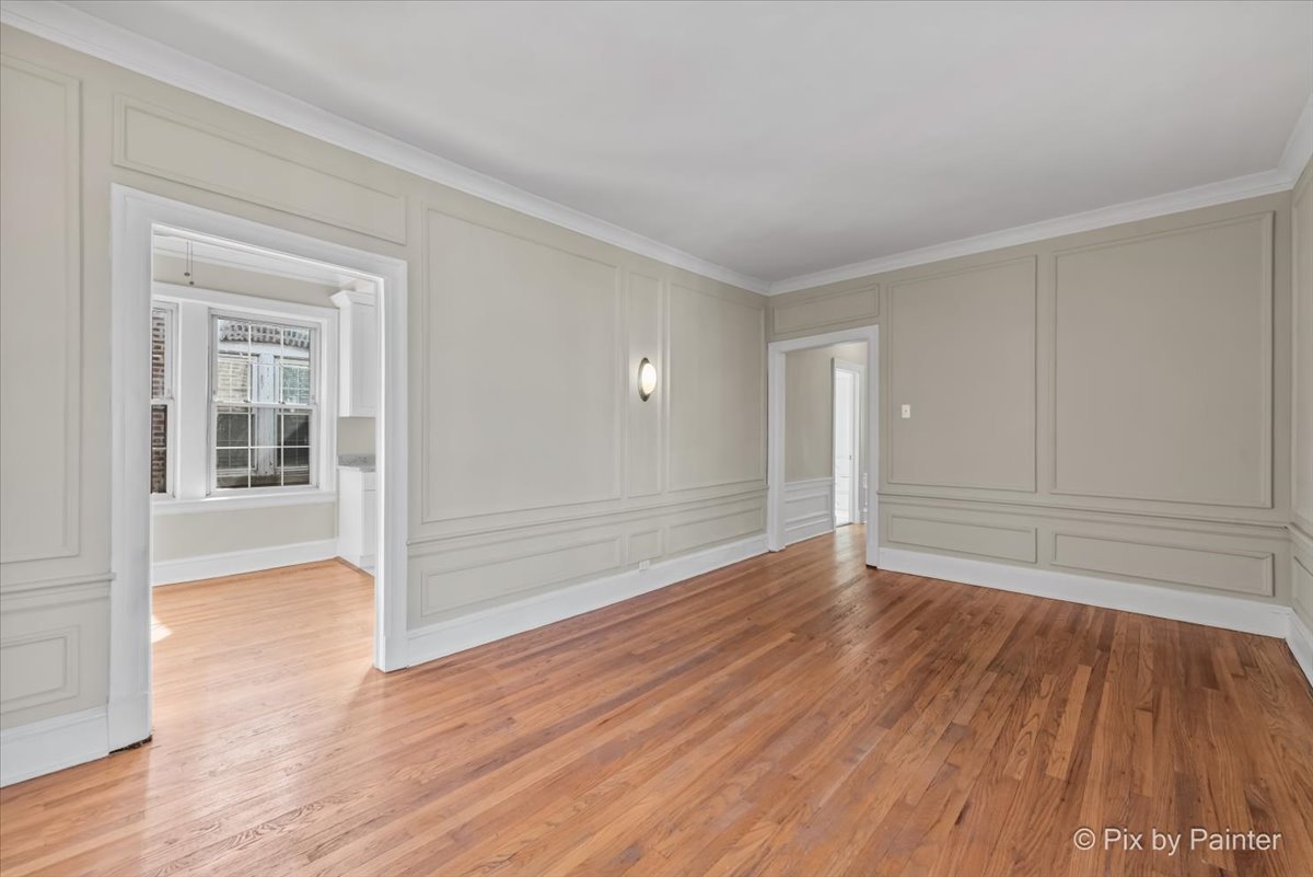 835 East 49th Street, Unit 3 Chicago, IL 60615 - Photo 3 of 16 wooden floor in an empty room with a window