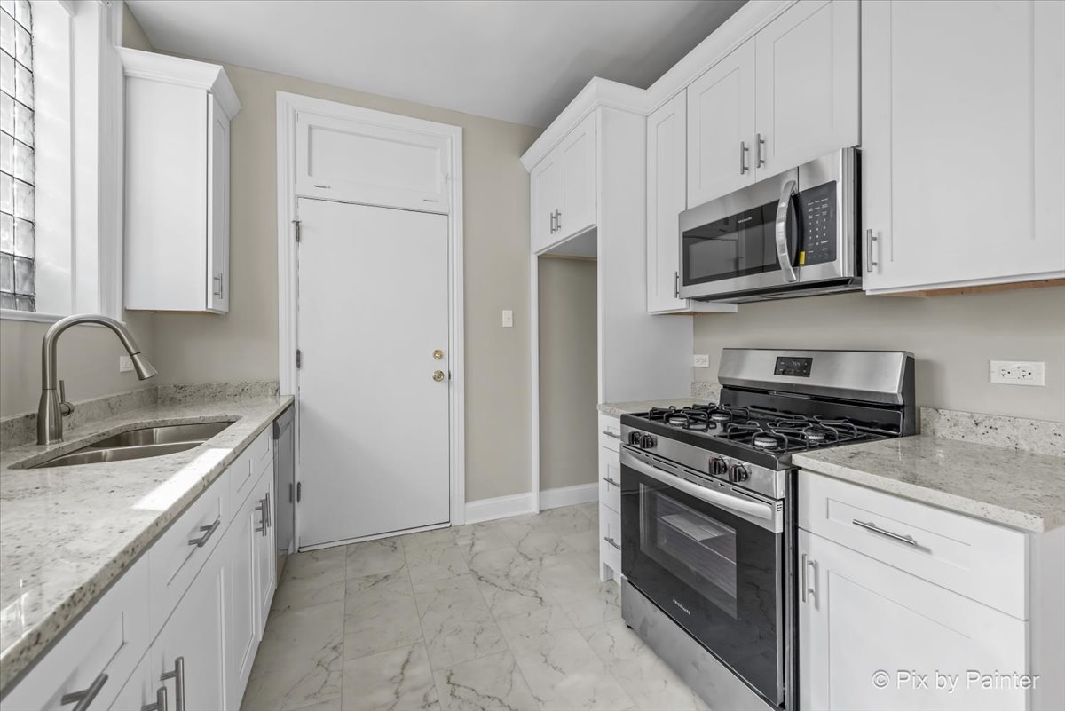 835 East 49th Street, Unit 3 Chicago, IL 60615 - Photo 7 of 16 a kitchen with stainless steel appliances granite countertop white cabinets a stove top oven a sink and dishwasher