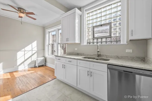a kitchen with granite countertop white cabinets and sink