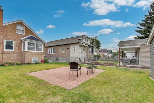 a view of a house with backyard and sitting area