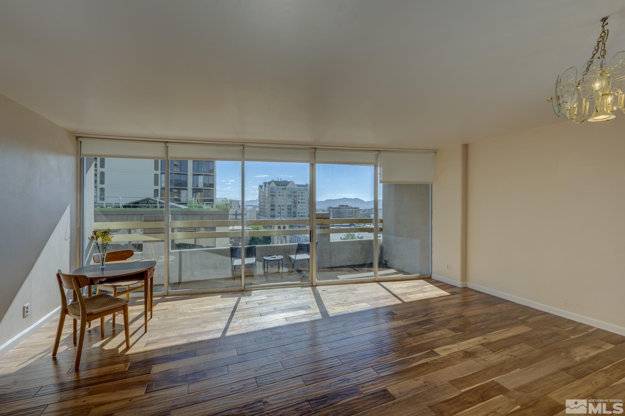 100 North Arlington Avenue, Unit 6B Reno, NV 89501 - Photo 3 of 23 a dining room with wooden floor and a floor to ceiling window