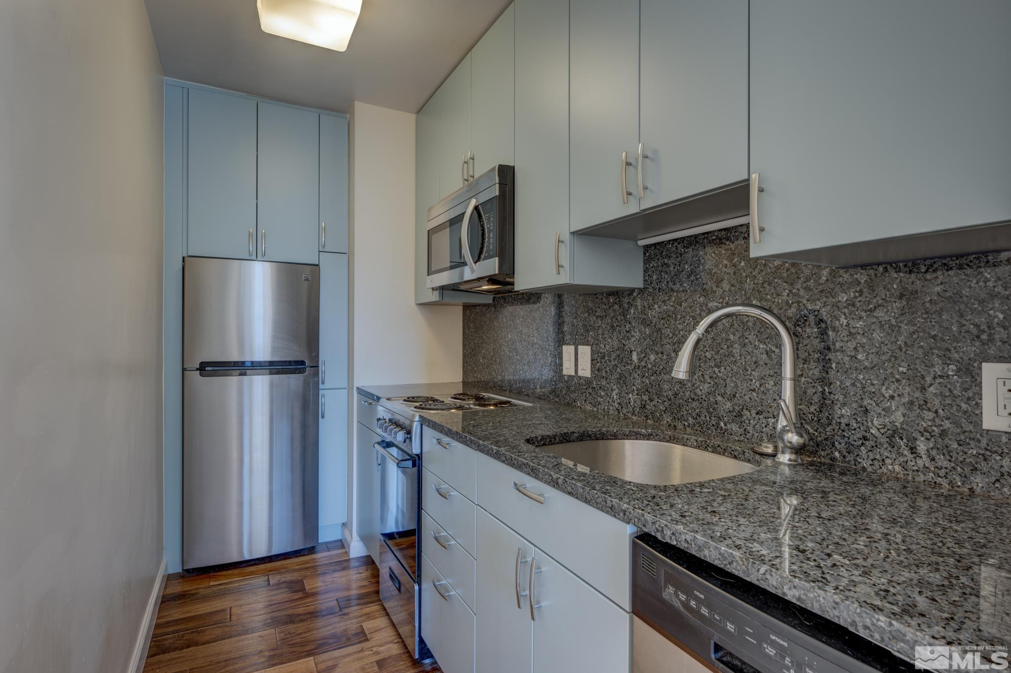100 North Arlington Avenue, Unit 6B Reno, NV 89501 - Photo 5 of 23 a kitchen with stainless steel appliances granite countertop a sink stove and refrigerator