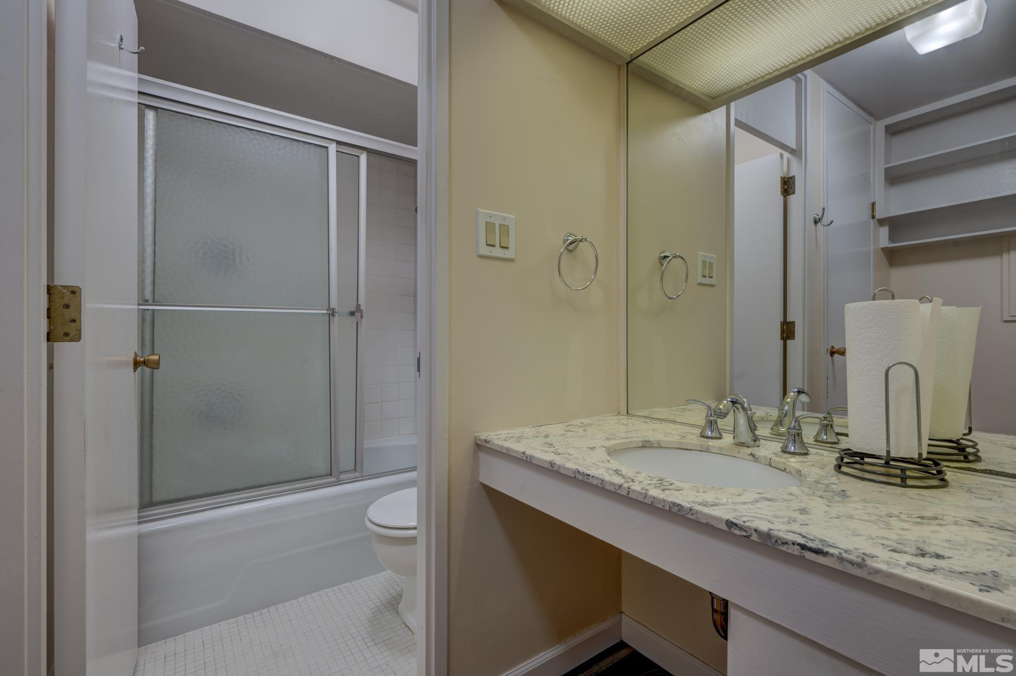 100 North Arlington Avenue, Unit 6B Reno, NV 89501 - Photo 7 of 23 a bathroom with a granite countertop sink a toilet and shower
