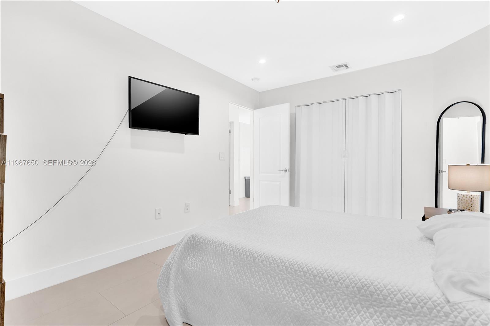8858 Southwest 214th Street Cutler Bay, FL 33189 - Photo 31 of 41 a bedroom with a bed and a flat screen tv