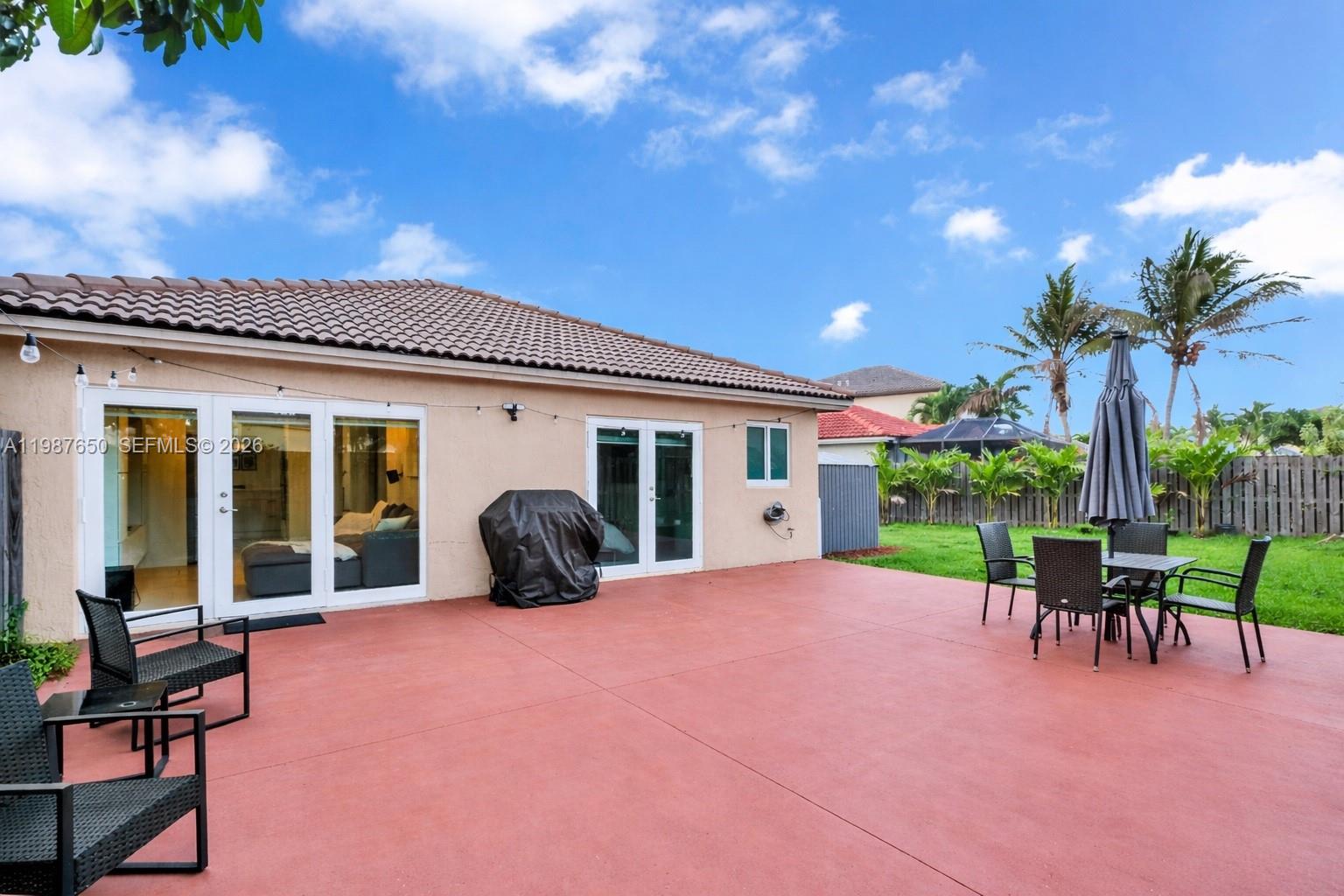 8858 Southwest 214th Street Cutler Bay, FL 33189 - Photo 37 of 41 a view of a patio with table and chairs with wooden floor and fence