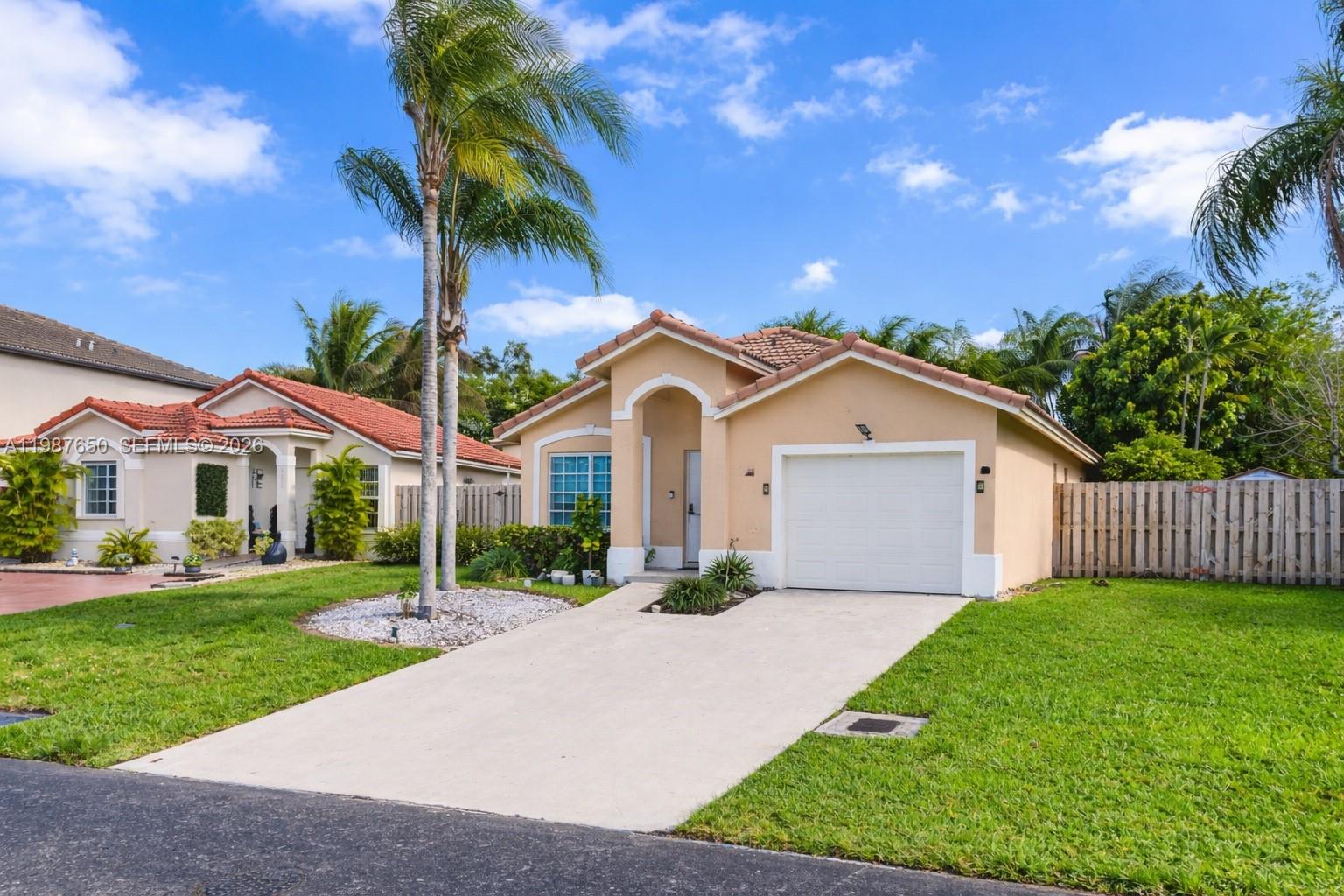 8858 Southwest 214th Street Cutler Bay, FL 33189 - Photo 4 of 41 a front view of a house with a yard and garage
