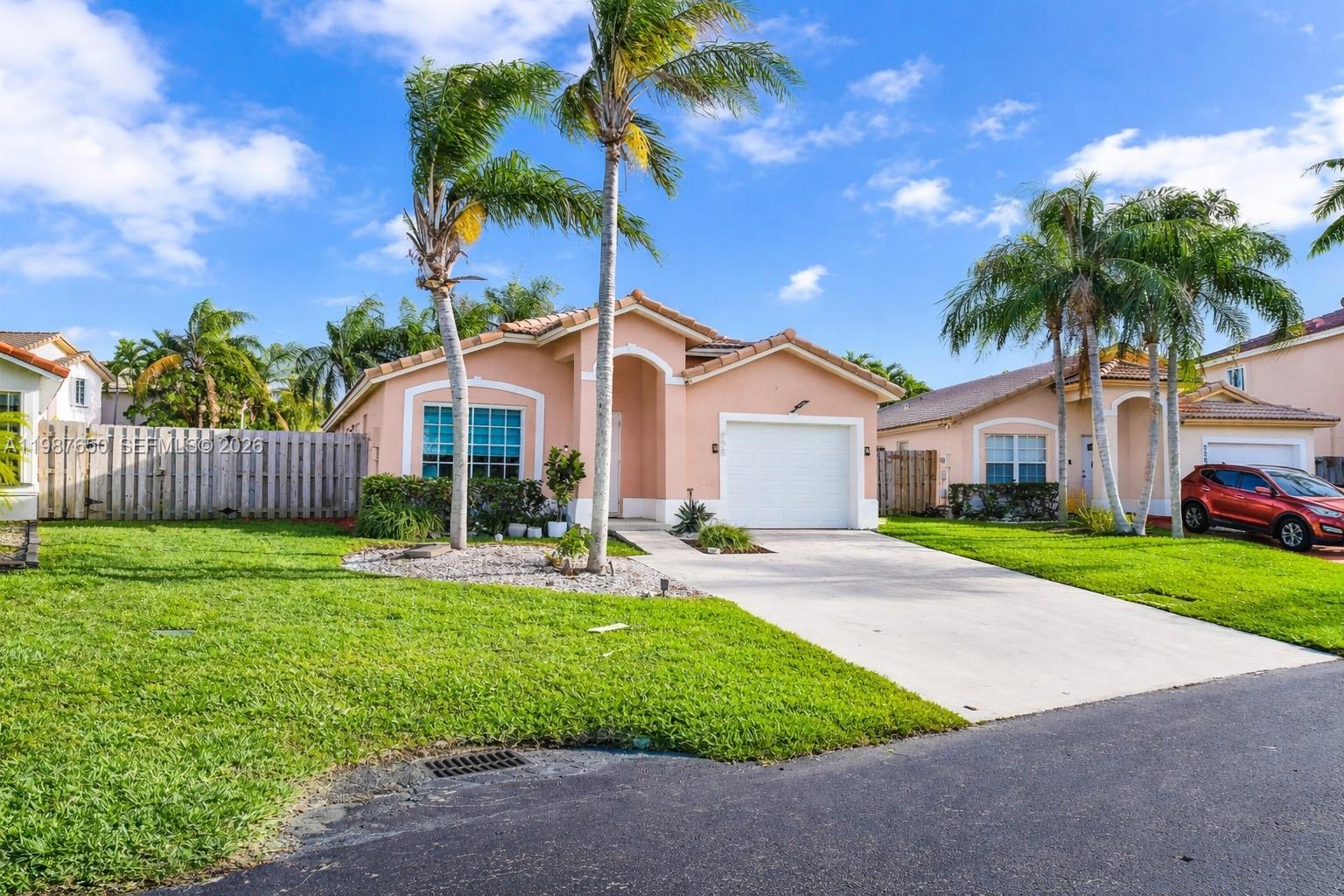 8858 Southwest 214th Street Cutler Bay, FL 33189 - Photo 5 of 41 a front view of a house with a yard and garage