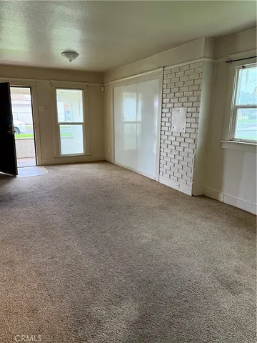 a view of an empty room with windows and closet