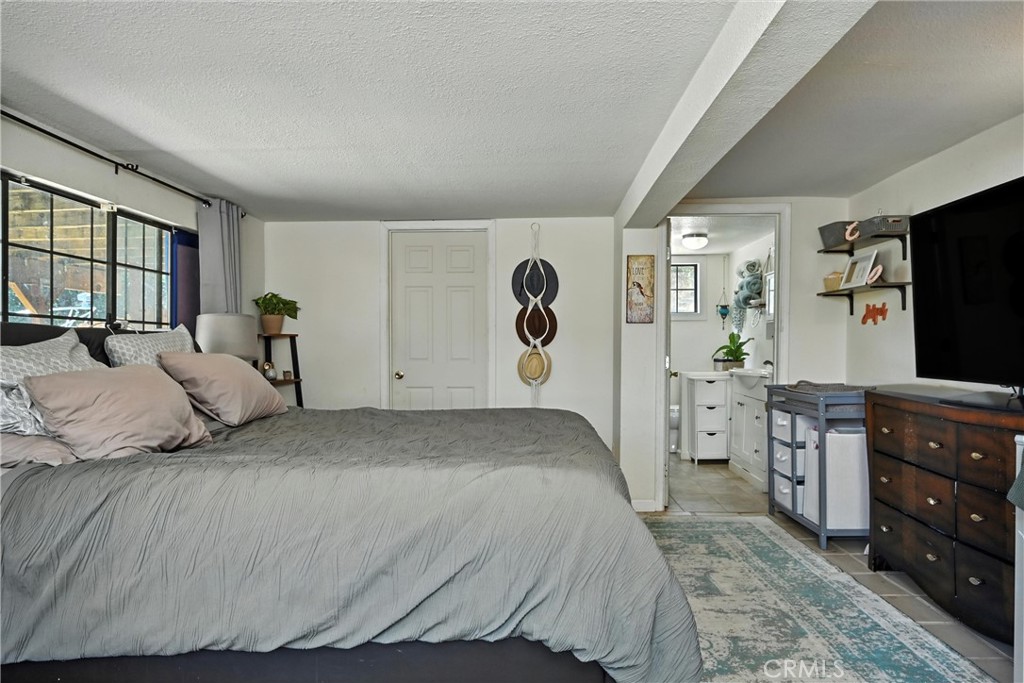 3171 Springe Street Nice, CA 95464 - Photo 13 of 28 a bedroom with a large bed and flat tv screen
