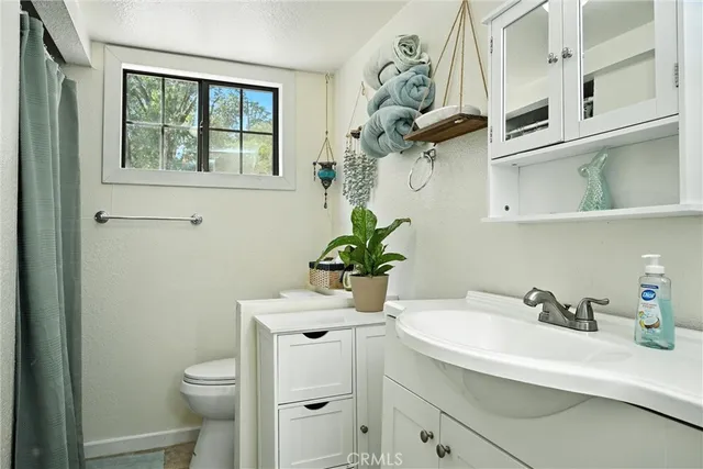 a bathroom with a sink a toilet and a window