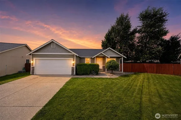 a front view of a house with yard and green space