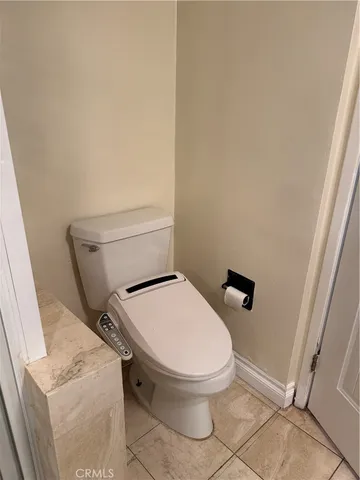 a white toilet sitting next to a shower