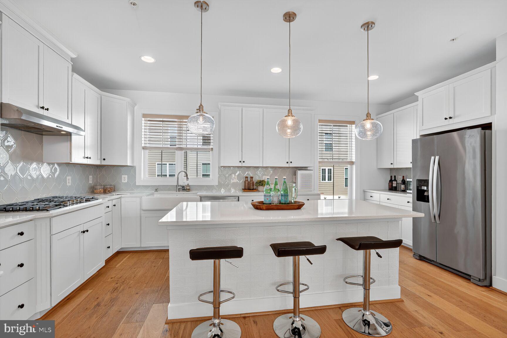 2373 Wyeth Street Silver Spring, MD 20906 - Photo 7 of 32 a kitchen with stainless steel appliances granite countertop a refrigerator a sink dishwasher a stove and white cabinets with wooden floor