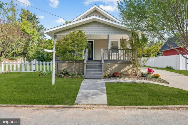 a front view of a house with a yard and potted plants