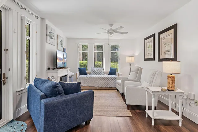 a living room with furniture wooden floor and a large window
