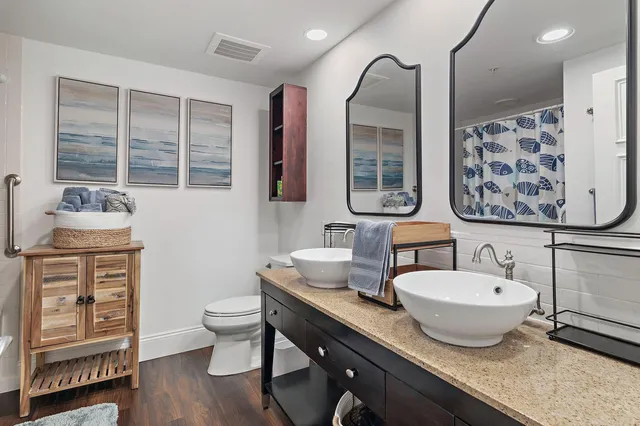 a bathroom with a granite countertop sink mirror and toilet