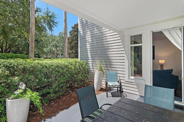 a view of a porch with chairs and potted plants