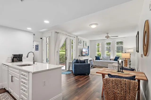 a living room with furniture a large window and wooden floor