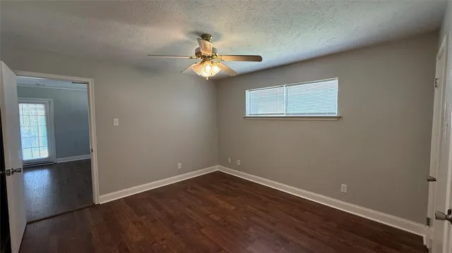 a view of empty room with wooden floor