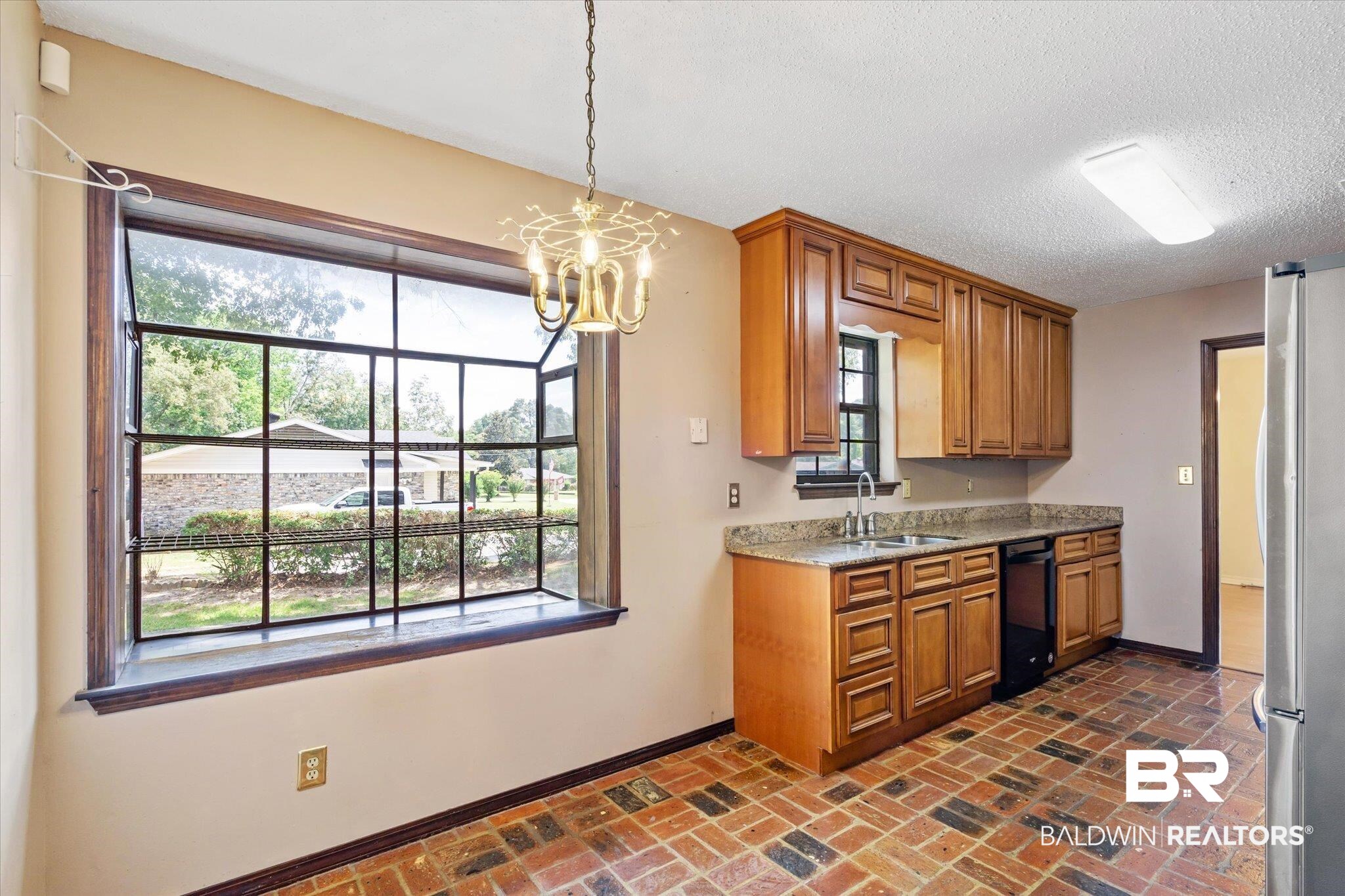 9623 Sunview Drive Semmes, AL 36575 - Photo 11 of 30 Kitchen with dishwasher, stainless steel refrigerator, a notable chandelier, sink, and a textured ceiling