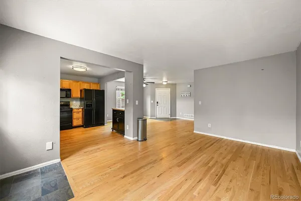 an empty room with windows and fan
