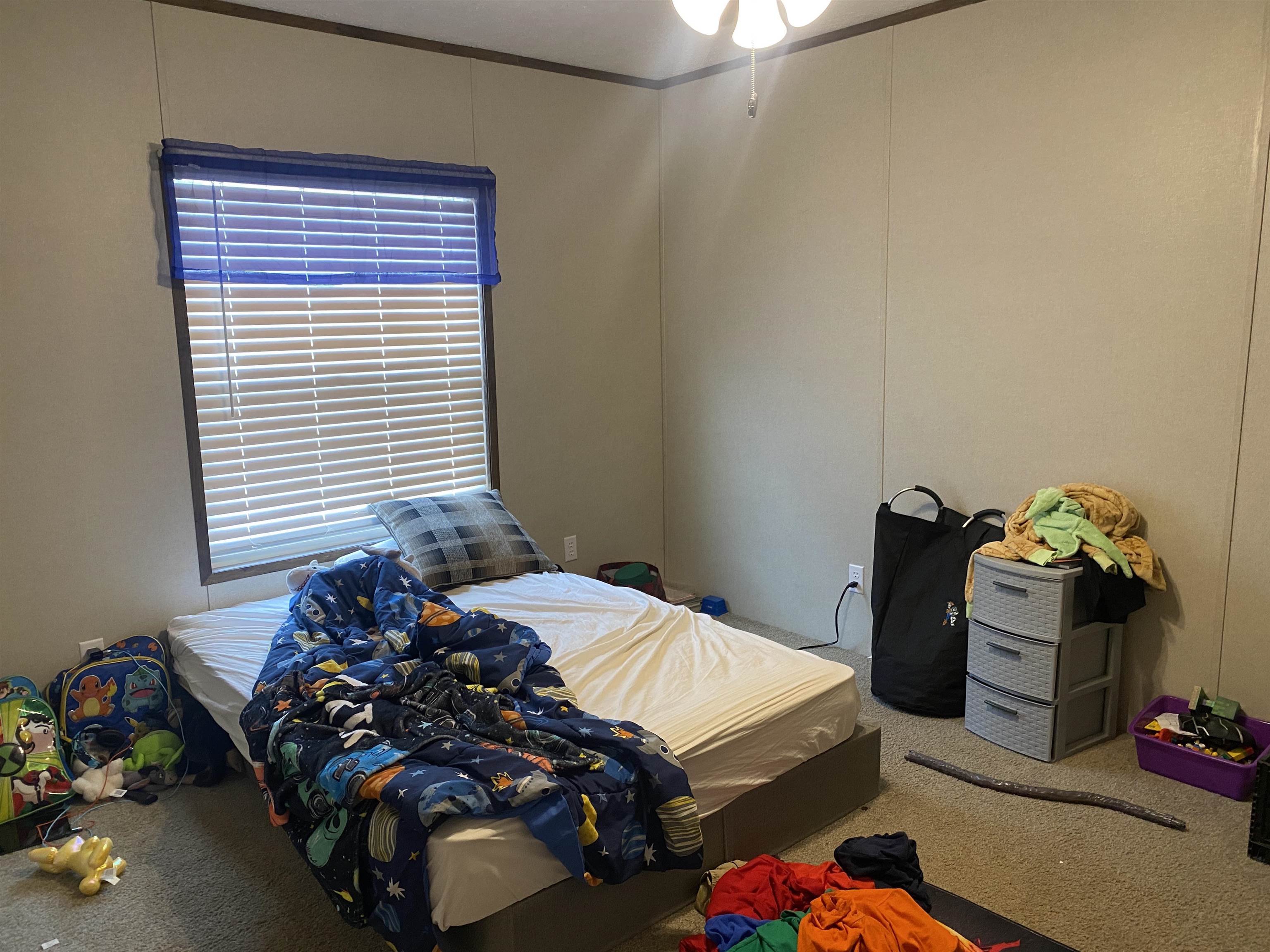 525 Sewell Bottom Road Adamsville, TN 38310 - Photo 26 of 37 a bedroom with a bed and a chandelier