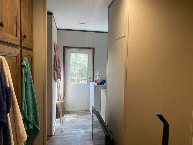 a view of a hallway with wooden floor and stairs