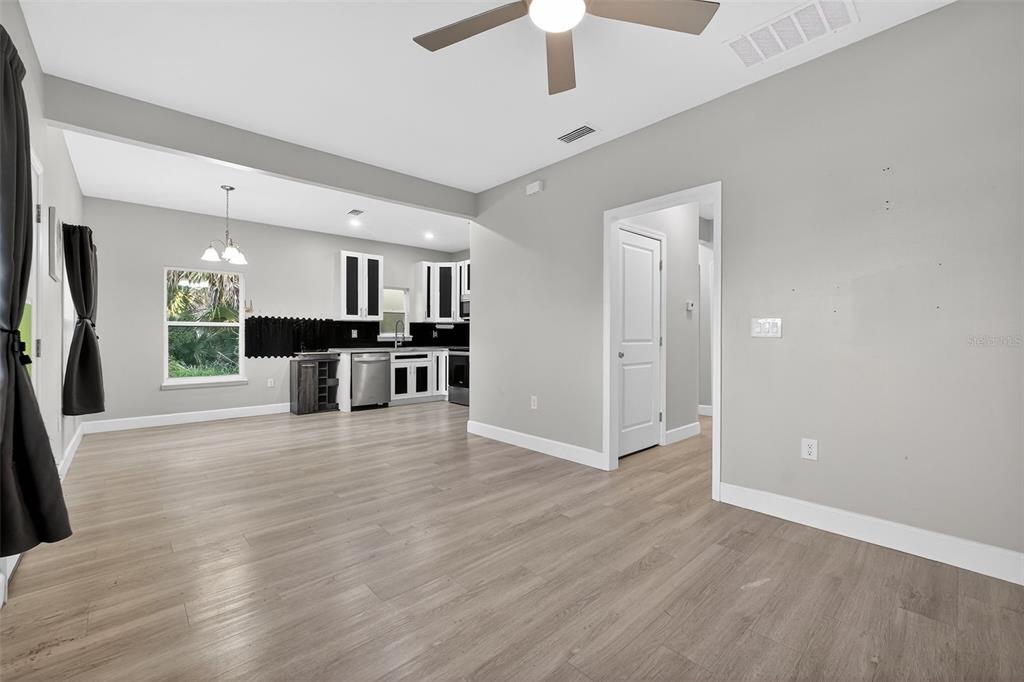 3633 Main Street Sanford, FL 32771 - Photo 11 of 31 an empty room with wooden floor and a kitchen