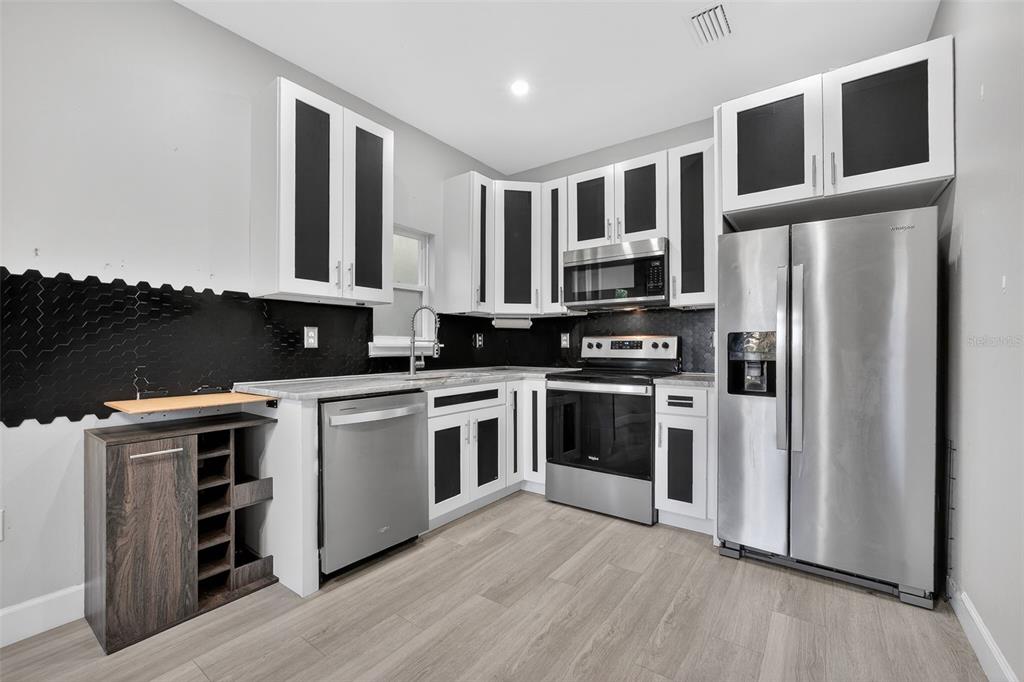 3633 Main Street Sanford, FL 32771 - Photo 7 of 31 a kitchen with stainless steel appliances granite countertop a stove a sink and a refrigerator