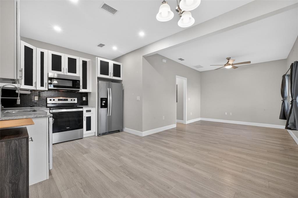 3633 Main Street Sanford, FL 32771 - Photo 9 of 31 a large kitchen with stainless steel appliances granite countertop a stove and a refrigerator