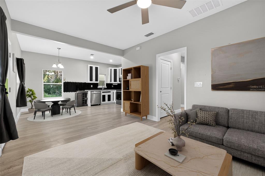 3633 Main Street Sanford, FL 32771 - Photo 10 of 31 a living room with furniture and a dining table with kitchen view