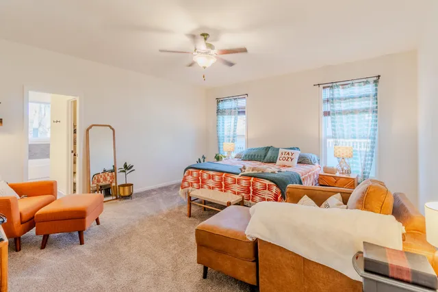 a bedroom with furniture and a large window
