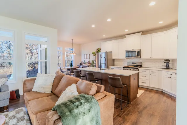 a living room with stainless steel appliances kitchen island granite countertop a couch and a view of living room