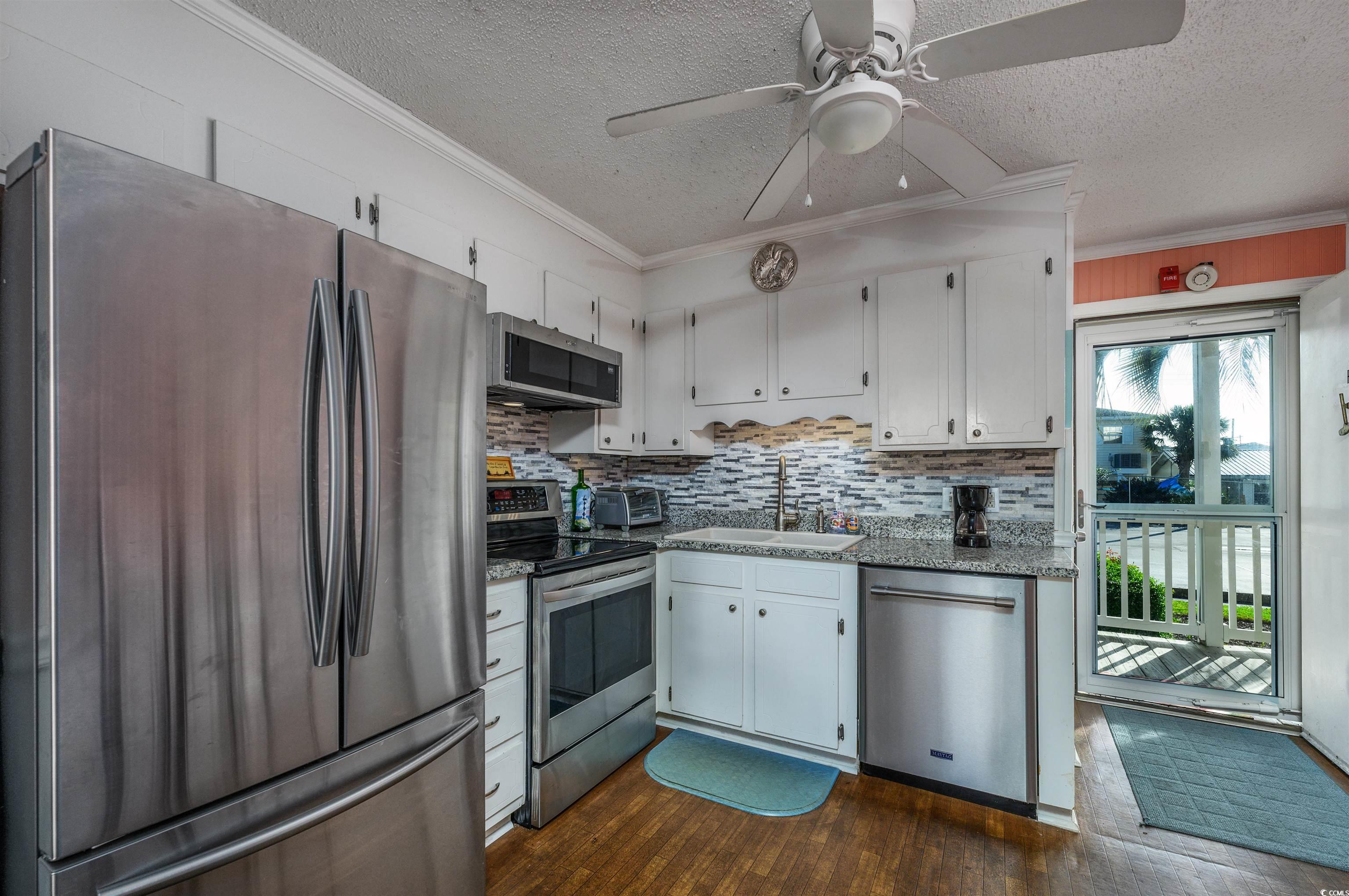 1919 Spring Street, Unit B14 North Myrtle Beach, SC 29582 - Photo 5 of 25 Kitchen with dark wood-type flooring, white cabine