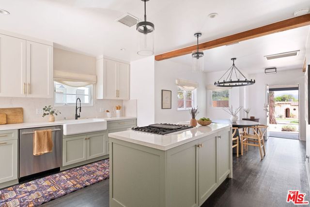 a kitchen that has a sink a stove and chairs