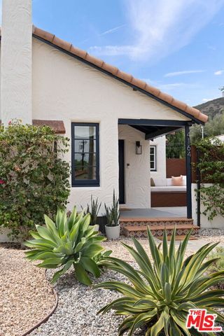 a front view of a house with plants