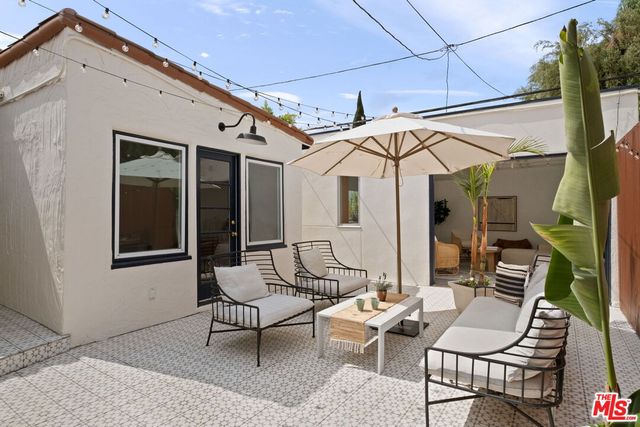 a patio with a glass top table and chairs