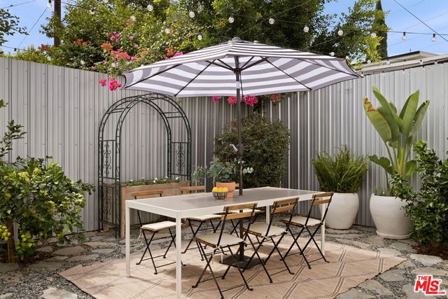 a patio with a table and chairs under an umbrella
