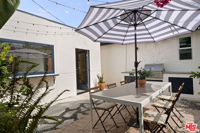a patio with a table and chairs under an umbrella