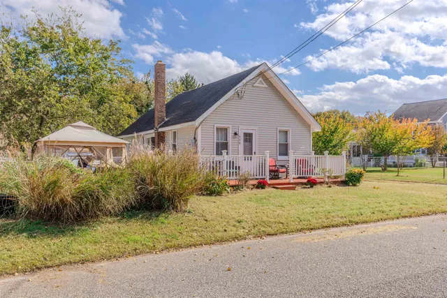 a front view of a house with a garden and trees